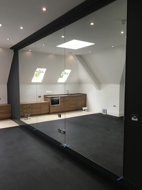 Frameless glass partition in loft conversion by Chessington glaziers