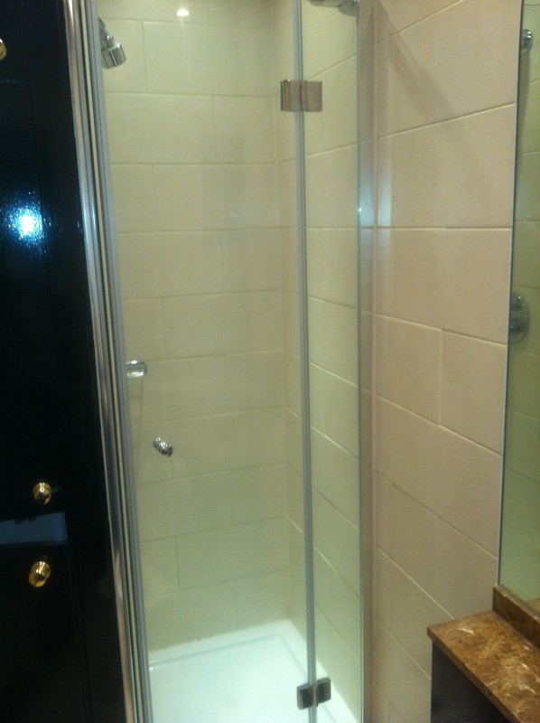 Frameless glass shower enclosure with chrome fittings in Chessington