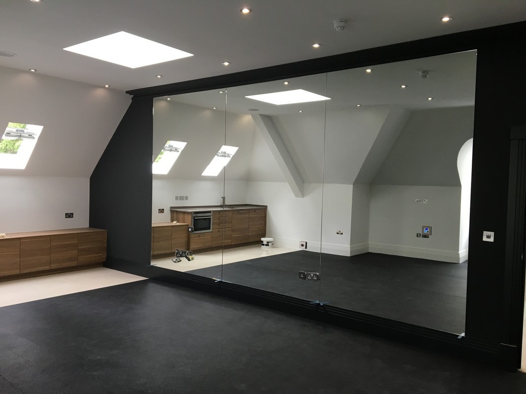 Frameless glass wall dividing loft conversion in Chessington